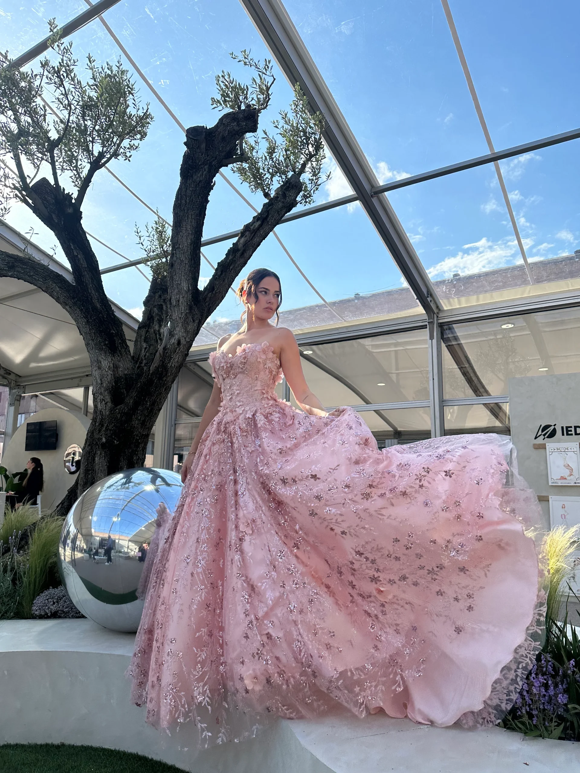 Model wearing a stunning blush pink strapless ballgown with delicate floral embroidery, sparkling embellishments and a flowing full skirt, ideal for an alternative bridal look at MK Bride Milton Keynes. Model wearing a stunning blush pink strapless ballgown with delicate floral embroidery, sparkling embellishments and a flowing full skirt, ideal for an alternative bridal look at MK Bride Milton Keynes.